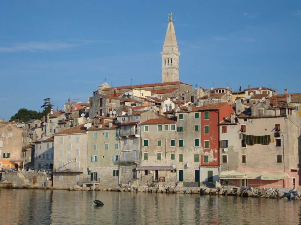 Coastal town with historic buildings and a tall bell tower.