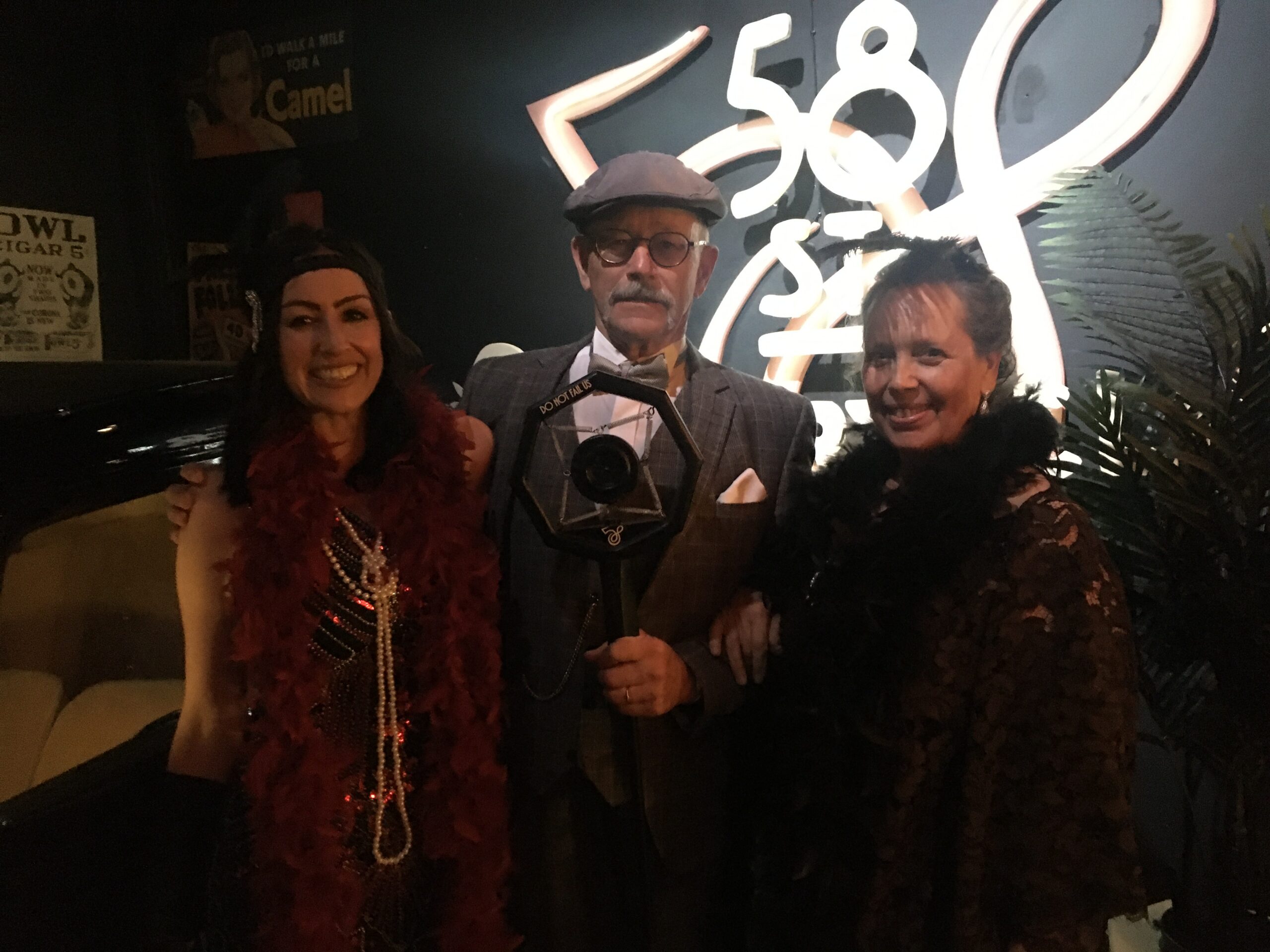 Three people in 1920s-style outfits posing