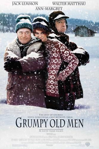 Three men in winter clothes standing back-to-back in the snow.