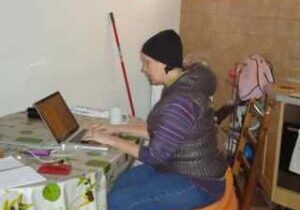 Person sitting at a table using a laptop.